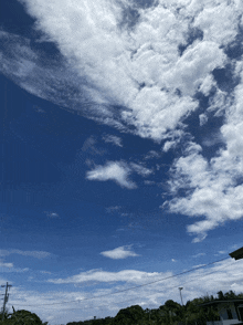 a blue sky with white clouds and power lines