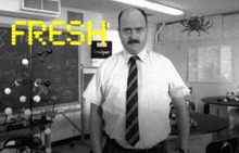 a man in a tie stands in front of a blackboard with the word fresh on it