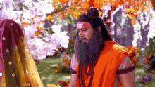 a man with a beard and a red headband is sitting in front of a woman in a yellow dress .