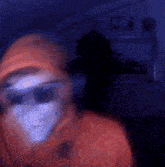 a blurry image of a person wearing sunglasses and a mask