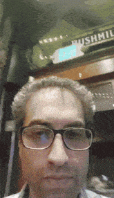 a man wearing glasses is standing in front of a pushmt sign