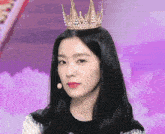 a woman is wearing a crown on her head and looking at the camera