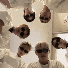 a group of young men wearing sunglasses and white shirts
