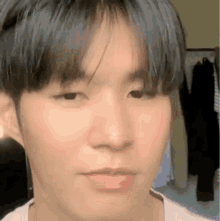 a close up of a young man 's face with a slight smile on his face .
