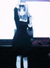 a blurry picture of a girl in a black dress standing in front of a white board .