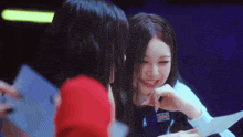 two young women are laughing and looking at each other in a dark room .