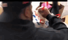 a man wearing a black hat is holding a pink item .