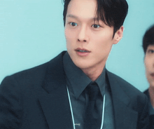 a man in a suit and tie with a lanyard around his neck