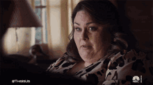 a woman sitting in front of a lamp with the hashtag thisisus