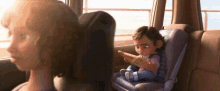 a woman is sitting in the back seat of a car with a baby in a car seat .