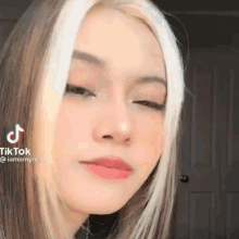 a close up of a woman 's face with blonde streaks .