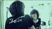 a person wearing a black shirt that says ' antisocial ' on the back