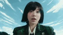 a girl in a plaid jacket has the letter b on her jacket