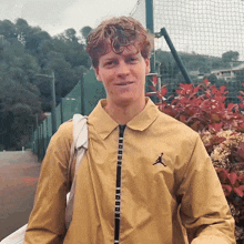 a man wearing a yellow jacket with an air jordan logo