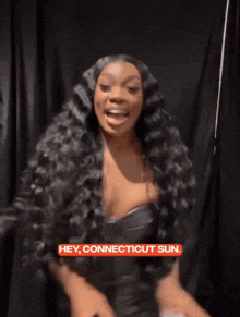 a woman with long black hair is smiling with the words hey connecticut sun above her