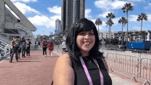 a woman wearing a lanyard with the letter n on it smiles