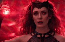 scarlet witch is holding a red glowing object in her hand .
