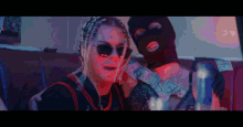 a woman wearing sunglasses is sitting next to a man wearing a mask and holding a bunch of money