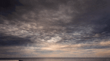a dark cloudy sky over a body of water with a website url at the bottom right