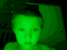 a child 's face is glowing in green light