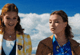 two women standing next to each other with one wearing a blue shirt