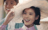 a woman wearing a white hat is smiling with a man behind her