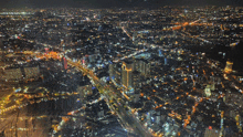 an aerial view of a city at night with lots of buildings lit up