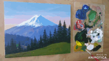 a painting of a mountain and trees next to a palette that says made in animotica
