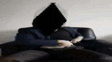 a man in a suit is sitting in a chair with a black diamond covering his face