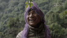 a person wearing a purple scarf on their head with vice written on the bottom right