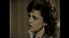 a close up of a woman 's face with a serious look on her face in a dark room .