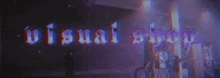 the word visual shop is displayed in a dark room