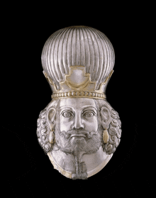 a silver sculpture of a man with a beard and a crown on his head