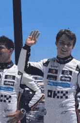 two race car drivers are standing next to each other and one is wearing a dell technologies shirt