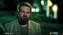 a man with a beard is featured on a nbc poster