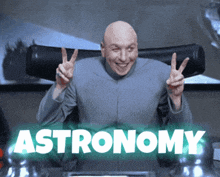 a bald man giving a peace sign with the word astronomy behind him