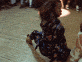 a man in a floral shirt is kneeling down on the floor