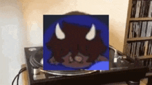 a picture of a cartoon character with horns on a record player .