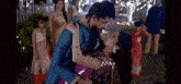 a man is holding a woman in his arms and kissing her .