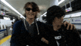 a man wearing sunglasses and a black shirt that says anice