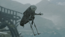 a skeleton is flying in the air in front of a bridge and mountains