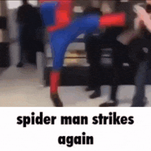 a spider man is standing in front of a crowd of people in a blurry photo .