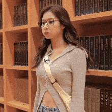 a woman wearing glasses is standing in front of a bookshelf with books in korean