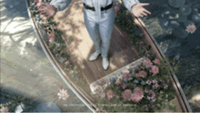 a man is standing in a boat with flowers on the deck