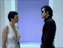 a man and a woman are looking at each other in a room .