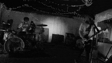 a man is playing a guitar in a black and white photo .