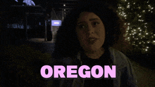 a woman singing in front of a sign for oregon