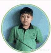 a young boy in a green shirt is standing in a circle with a blue background