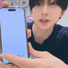 a man is holding a cell phone with a blank screen