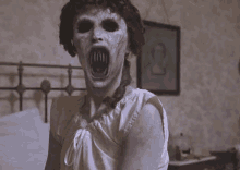 a woman with a scary face is standing next to a bed